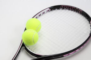 テニスラケット1本とテニスボール2個が置かれている