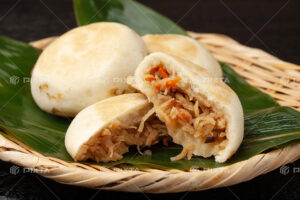 信州の郷土食「おやき」が3つざるの上に並んでいて1つは断面がみえるように割ってある